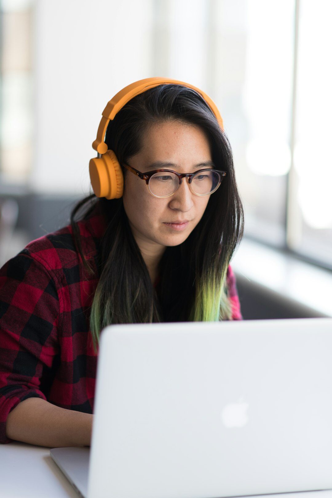Woman with headphones working on a laptop