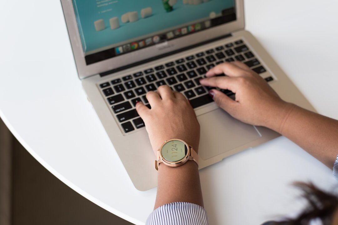 Hands typing on a laptop showing growth charts