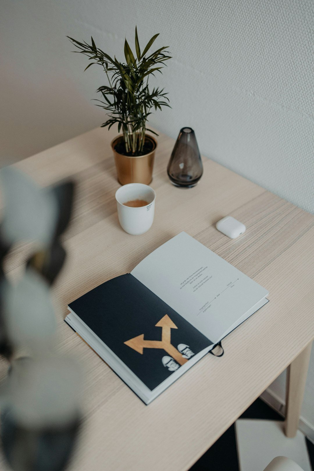 Desk with notebook, coffee cup and plant